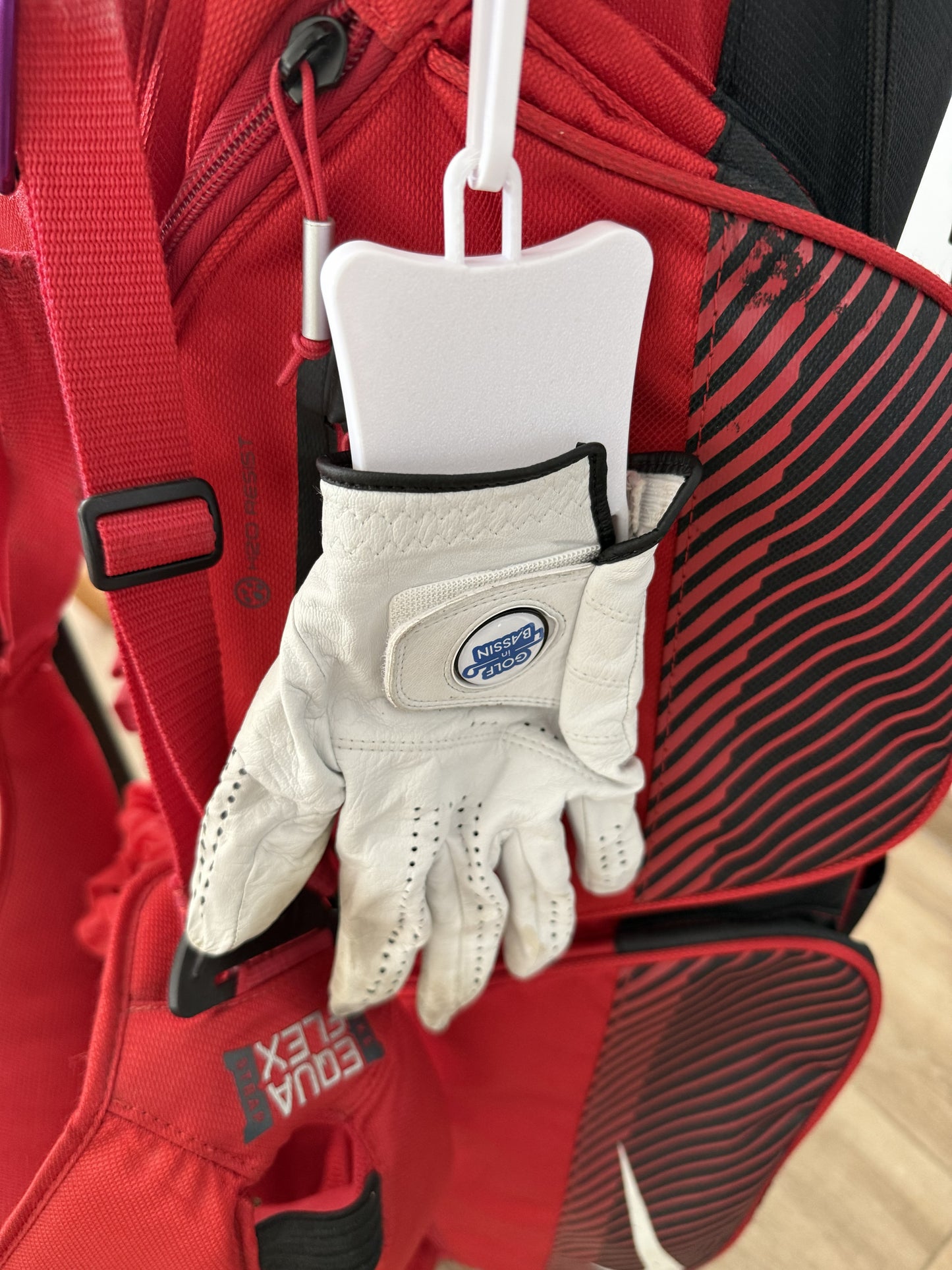 Sécheur de gant accroché à un sac de golf via mousqueton intégré